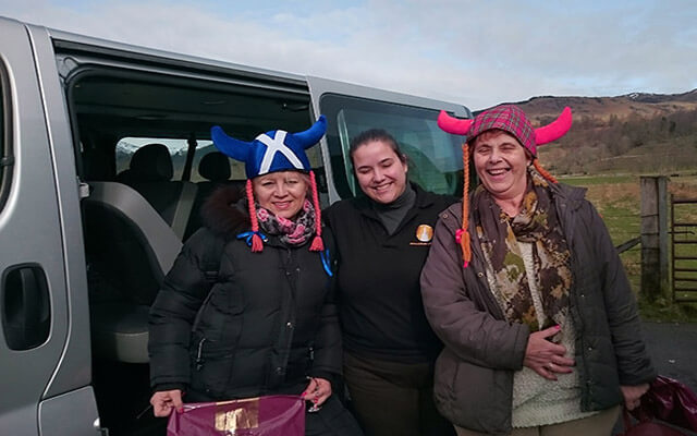 María Santana, guía oficial en Escocia, con dos viajeras con sombreros escoceses, durante una excursión al Lago Lomond