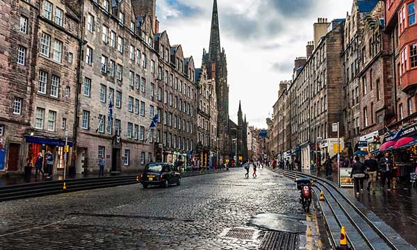 Calle adoquinada Royal Mile con antigua iglesia al fondo