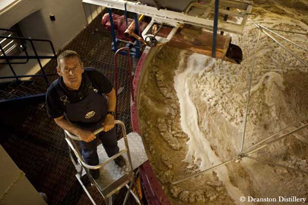 Trabajador dentro de una destilería de whisky en Escocia