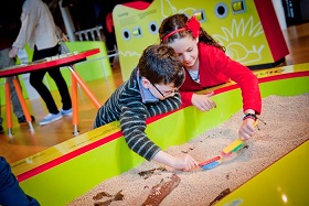 Dos niños jugando con arena en el museo nacional de Escocia en Edimburgo